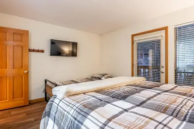 a bedroom with a bed and a tv on the wall at Summit #269 - 2 Bedrm 2 Bathrm Condo - Walk To Eagle Lodge Lifts in Mammoth Lakes