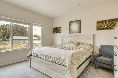 a bedroom with a bed and a chair and a window at Chowchilla Home with Private Patio! in Chowchilla