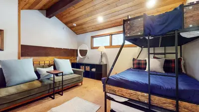 a room with two bunk beds and a couch at Woodlands #40 condo in Mammoth Lakes