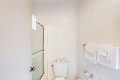 a white bathroom with a toilet and towels at Sierra Park Villas 56 L in Mammoth Lakes