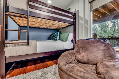 a bedroom with a bunk bed and a couch at Upscale Incline Village Home with Hot Tub & Sauna in Incline Village