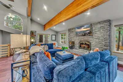 a living room with blue couches and a stone fireplace at Upscale Incline Village Home with Hot Tub & Sauna in Incline Village
