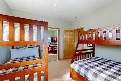 a bedroom with two bunk beds and a hallway at Skislope Serenity in Truckee