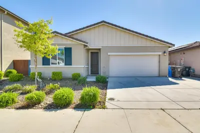 a house with a driveway and a garage at WFH-Friendly Getaway with Yard in Manteca! in Manteca