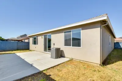 a house with a driveway with a trash can at WFH-Friendly Getaway with Yard in Manteca! in Manteca
