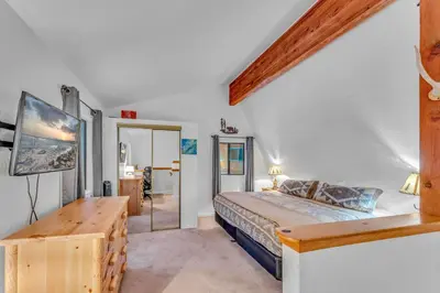 a bedroom with a bed and a table and a mirror at White Fir Chalet Dog Friendly Cabin in the Woods in Soda Springs