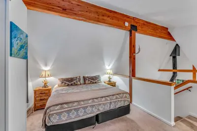 a bedroom with a bed and two lamps on tables at White Fir Chalet Dog Friendly Cabin in the Woods in Soda Springs