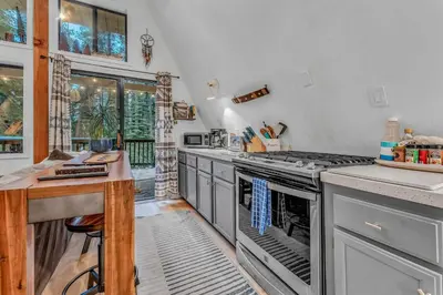 a kitchen with stainless steel appliances and a table at White Fir Chalet Dog Friendly Cabin in the Woods in Soda Springs