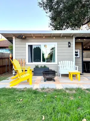 a patio with two yellow chairs and a table at 2 Private Bedroom Suites with Hot Tub in Sacramento