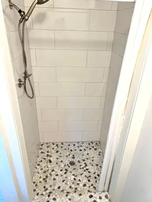 a bathroom with a shower with a tiled floor at 2 Private Bedroom Suites with Hot Tub in Sacramento