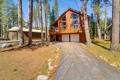a house in the woods with a driveway at Snowshoe and Sled On-Site! Soda Springs Cabin in Soda Springs