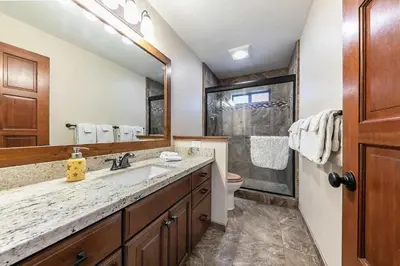 a bathroom with a sink and a toilet and a mirror at Northstar Family Retreat on Shuttle Line with Deck in Truckee