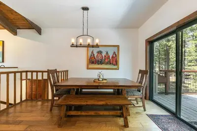a dining room with a wooden table and a chandelier at Northstar Family Retreat on Shuttle Line with Deck in Truckee