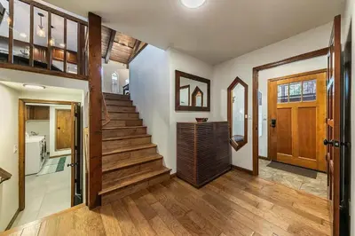 a hallway with a staircase with wooden floors and a door at Northstar Family Retreat on Shuttle Line with Deck in Truckee