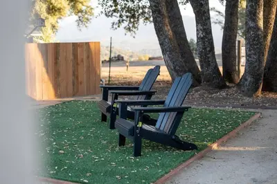 two empty chairs sitting on grass in a park at Stunning views with pool, spa, gold panning, firepit, game court and BBQ in Ahwahnee