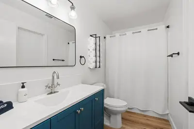 a bathroom with a sink and a toilet and a mirror at Stunning views with pool, spa, gold panning, firepit, game court and BBQ in Ahwahnee