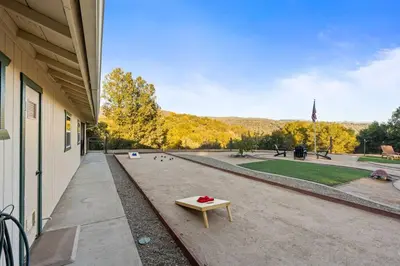 a bench sitting outside of a building with a park at Stunning views with pool, spa, gold panning, firepit, game court and BBQ in Ahwahnee