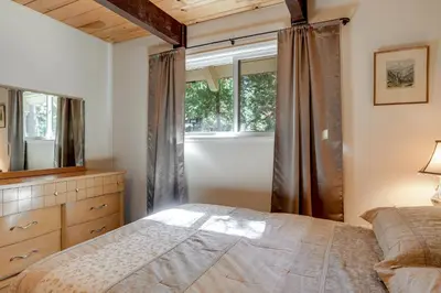 a bedroom with a large bed and a window at Arnold Chalet Near Town and Calaveras Big Trees! in Arnold