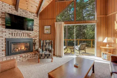a living room with a fireplace and a tv at Arnold Chalet Near Town and Calaveras Big Trees! in Arnold