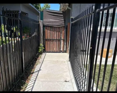 a black fence with a gate and a sidewalk at Charming Casita all too yourself near Midtown, Train and Freeway in Sacramento