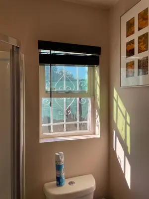a bathroom with a window over a toilet and a toilet paper at Charming Casita all too yourself near Midtown, Train and Freeway in Sacramento