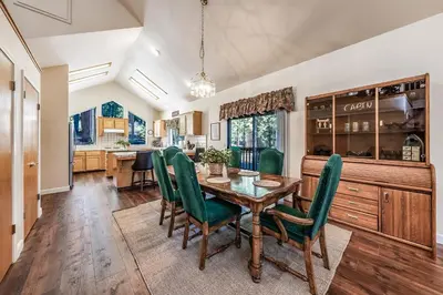 a dining room with a wooden table and green chairs at Granite Ridge Getaway Chill Deck Vibes AC in Shaver Lake