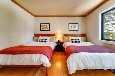 two beds in a small room with a window at 6 Mi to Ski Slopes! Family Tahoe Cabin with 3 Decks in Tahoe Vista