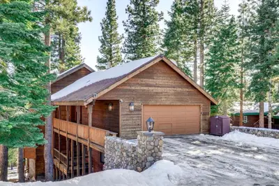 a log house with a garage in the woods at 6 Mi to Ski Slopes! Family Tahoe Cabin with 3 Decks in Tahoe Vista