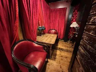 a room with a red curtain and a table and a chair at West River House in Truckee