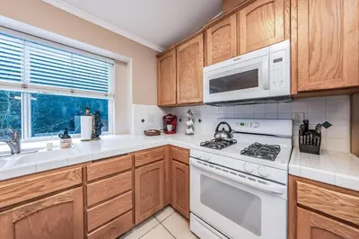 a kitchen with white appliances and wooden cabinets at Eagle Retreat Mountain Escape New With AC in Shaver Lake