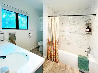 a bathroom with a tub and a sink and a shower at Modern Yosemite Cabin, 15min Bass Lake, Sleeps 8 in Oakhurst