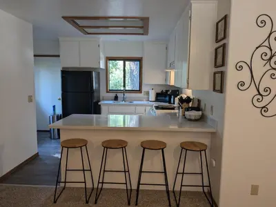 a kitchen with two bar stools and a counter top at Bulldog Den in Twain Harte