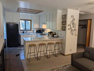 a kitchen with a counter and three bar stools at Bulldog Den in Twain Harte