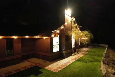 a house with lights on the side of it at night at Yosemite Forest Villa in Oakhurst