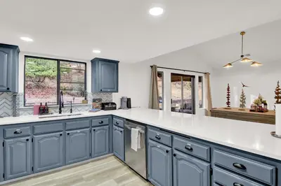 a kitchen with blue cabinets and white counter tops at Yosemite Forest Villa in Oakhurst