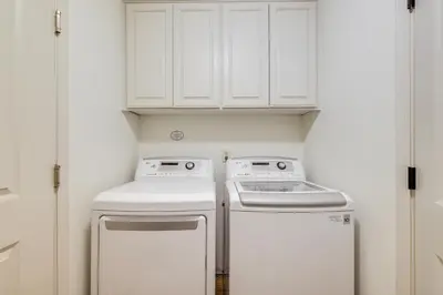 a kitchen with white cabinets and a washer and dryer at Forest-View Retreat Grill and Fireplace in Sonora in Sonora