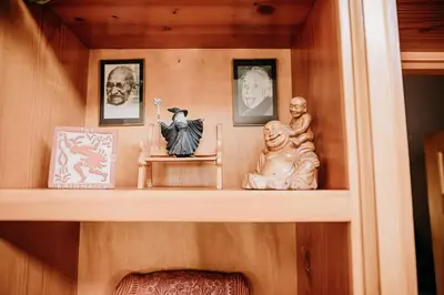 a shelf with statues and pictures on it at Oak Meadows House - A unique home near Yosemite in Mariposa
