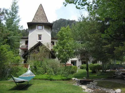 a house with a yard with a hammock in front of it at GetAways at Olympic Village Inn in Olympic Valley