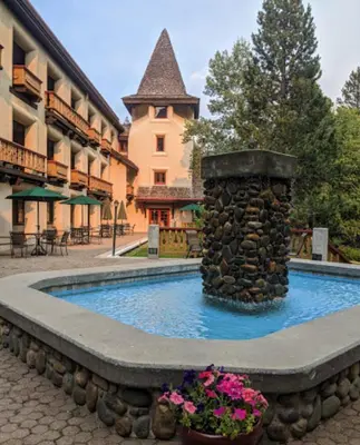 a fountain in the middle of a building with flowers at GetAways at Olympic Village Inn in Olympic Valley
