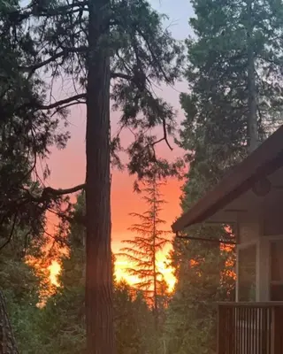 a sunset with a tree and a house at Family get away Near Sly Park Lake & Apple Hill in Pollock Pines