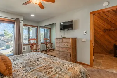 a bedroom with a bed and a dresser and a tv at Snowcreek #482 - Updated ! 3 Bedroom + Loft, 2 Bathroom, Sleeps 10! in Mammoth Lakes