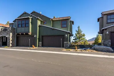 a green house with a garage on a street at Newly Built Townhome in Snowcreek Creekhouse #1324 Three Bed Three Baths Sleeps 8! Mountain Views! in Mammoth Lakes