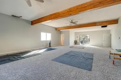 an empty living room with a ceiling fan and a rug at Water Views and Decks Spacious La Grange Retreat in La Grange