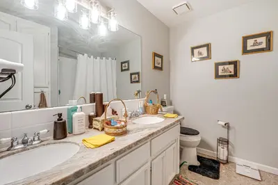a bathroom with two sinks and a large mirror at Water Views and Decks Spacious La Grange Retreat in La Grange