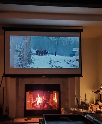 a large television hanging over a fireplace with a fire at Majestic View in Mariposa