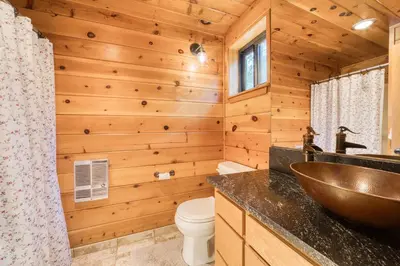 a log cabin bathroom with a sink and a toilet at Dwell by Tahoe Getaways - 3BR Tahoe Donner w Sauna & HOA Amenities in Truckee
