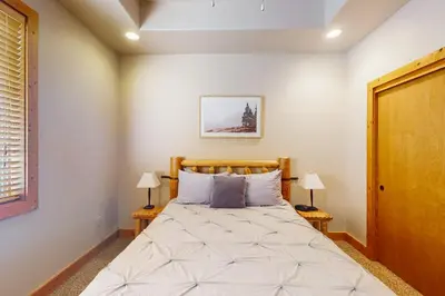 a bedroom with a large bed with two lamps at Baby Bear Bliss in Shaver Lake