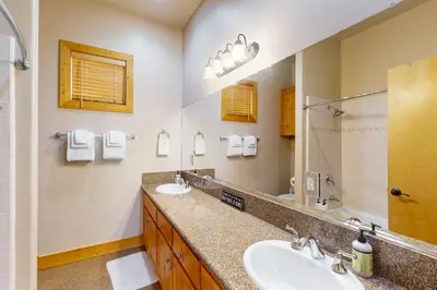 a bathroom with two sinks and a large mirror at Baby Bear Bliss in Shaver Lake
