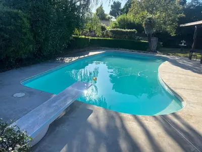 a swimming pool with blue water in a yard at Casa Pura Vida in Modesto