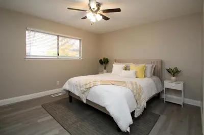 a bedroom with a bed with a ceiling fan at Entire Magill House by RiverPark in Fresno